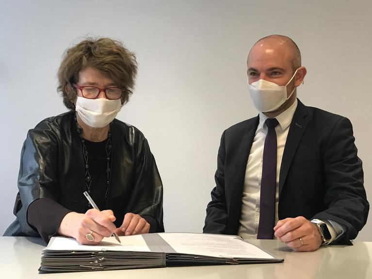 Béatrice Salmon, director of CNAP, and Marc Chassaubéné, president of Cité du design, sign the agreement.