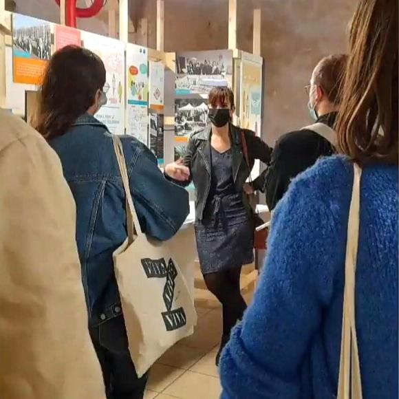 La directrice de l'Ecomusée du Grand-Orly Seine Bièvre, Anne-Laure Chambaz, est en train de mener une visite de l'exposition "La ville en partage"