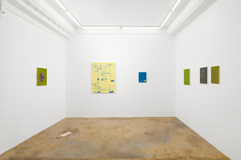 Vue de l'exposition, avec plusieurs peintures de mains ou d'escalier, une grande peinture abstraite jaune avec des tracés et le mot "door" écrit en bleu