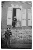 femme à la fenêtre tenant son chien et femme debout dans la rue tenant un porte-monnaie et une bouteille de vin en souriant